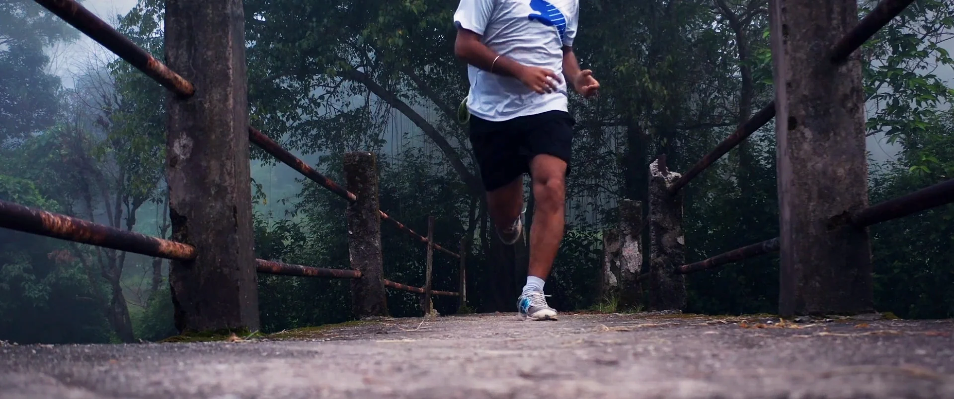 A runner on a forest boardwalk, seen from ground level
